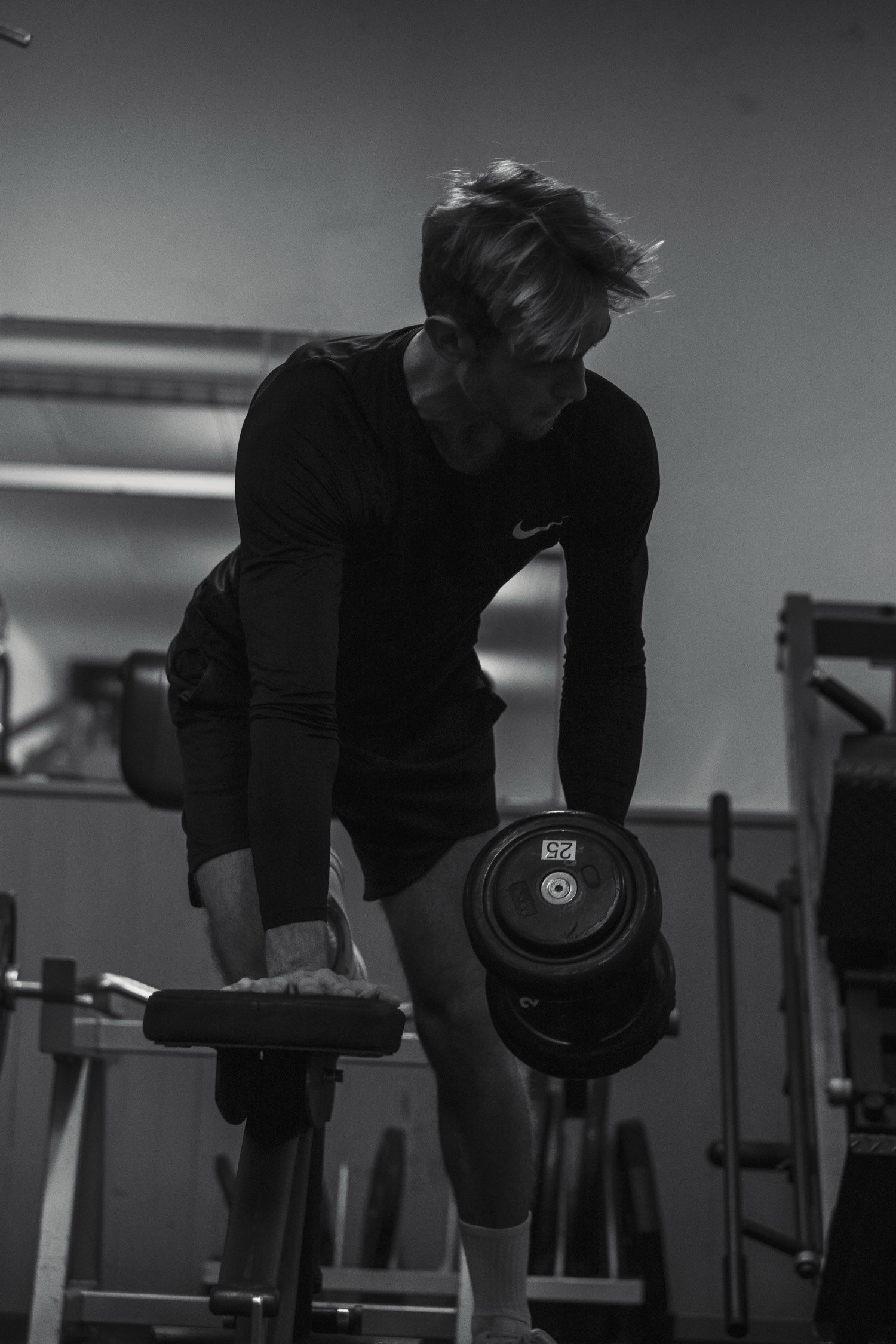 Homme en train de soulever un haltère, rowing haltère, salle de sport en noir et blanc